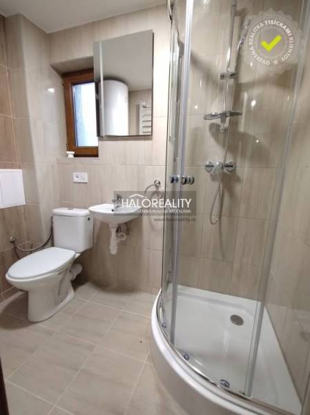 A bathroom in a studio apartment with a toilet, sink, and shower.