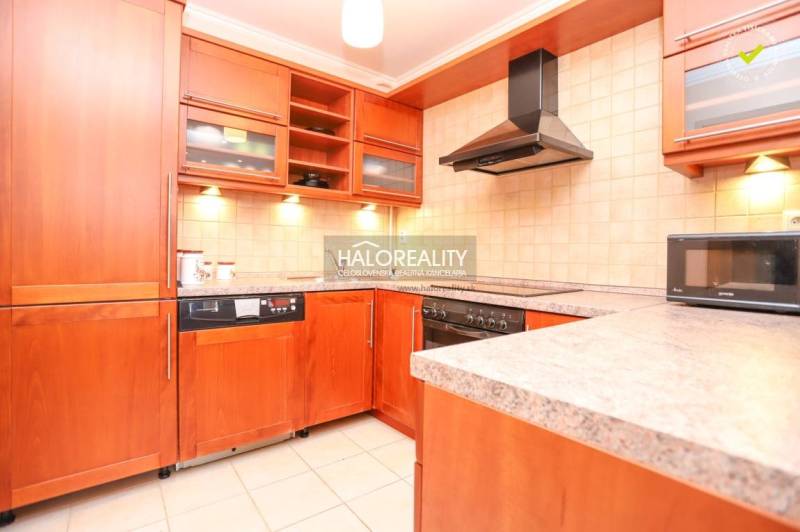 A kitchen in a 2-room apartment with a wooden cabinet and appliances, including a microwave.