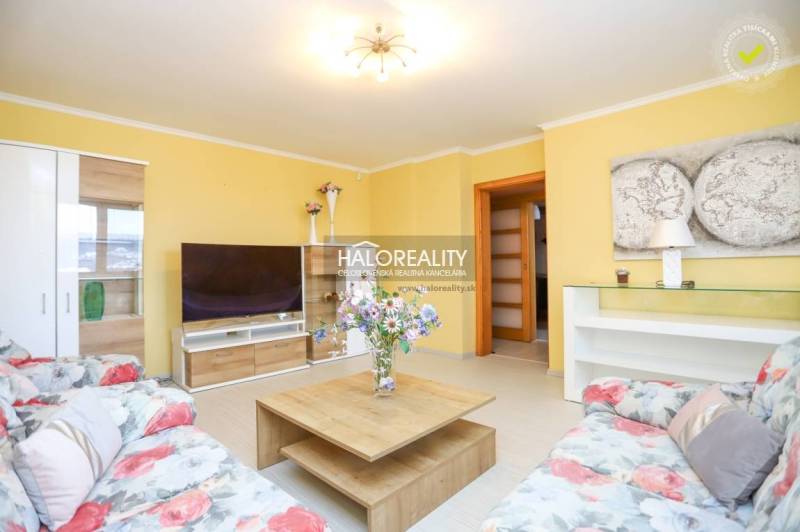 Living room in a 2-room apartment with a comfortable sofa, a table, and a television.