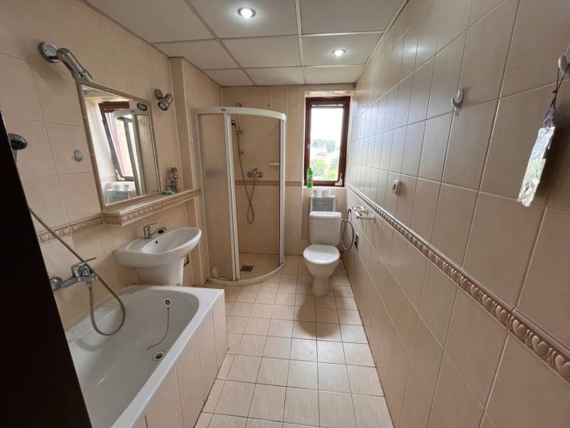A bathroom in a 2-room apartment with a bathtub, shower, sink, and toilet.