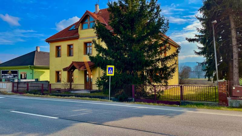 Yellow building on Chrabrany Street in Topoľčany with a sale announcement.