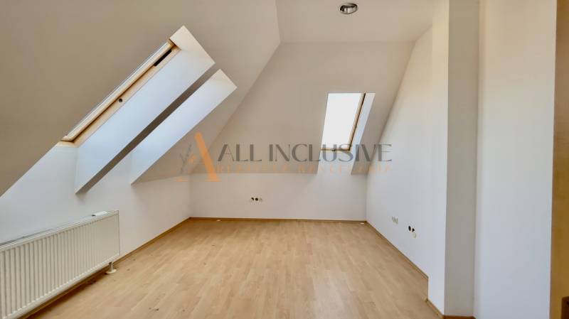 Attic space with wooden flooring and skylights in the building.