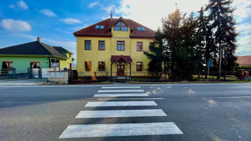 The building on Chrabrany Street in Topoľčany, opposite the pedestrian crossing and trees.