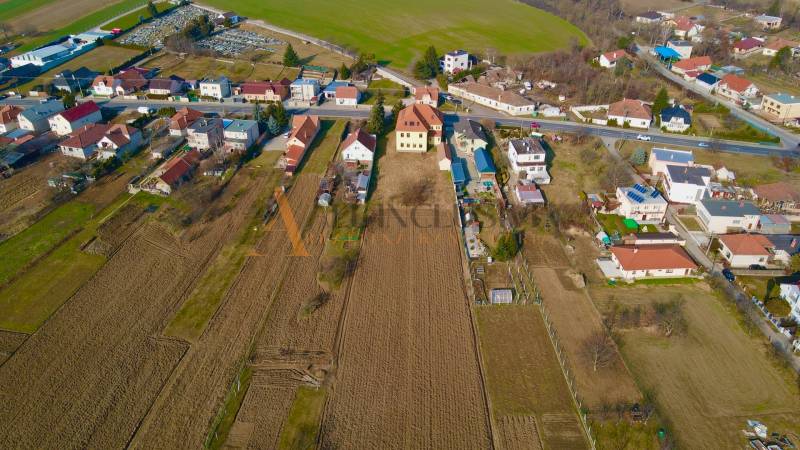 Aerial view of rural houses in Chrabrany near Topoľčany surrounded by fields and gardens.