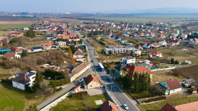 A view of houses and streets in Chrabrany, Topoľčany, under a clear sky.
