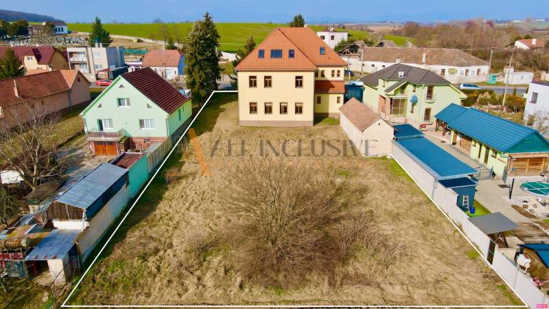 A building on Chrabrany Street in Topoľčany, surrounded by houses and a garden.