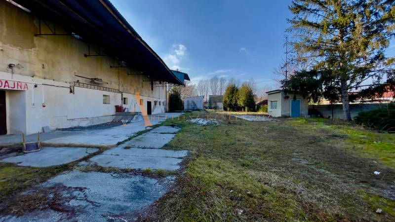 Production premises on Hlavná Street in Kovarce with greenery and buildings in the yard.