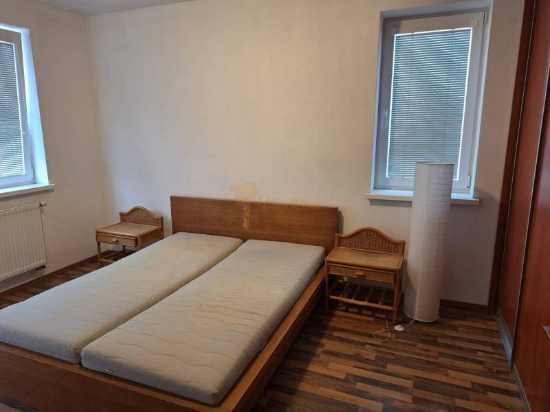 Bedroom in a 2-room apartment with a wooden bed and nightstands.