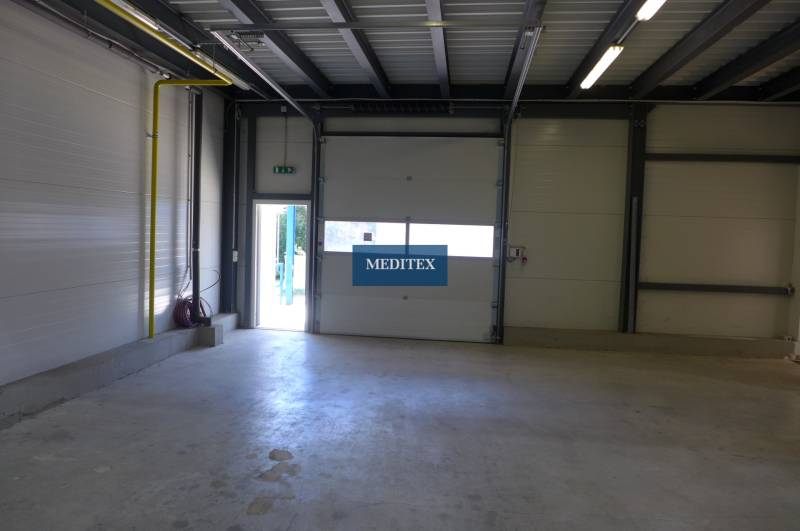 Industrial hall with large doors, steel structure, and lighting, suitable for warehouses.