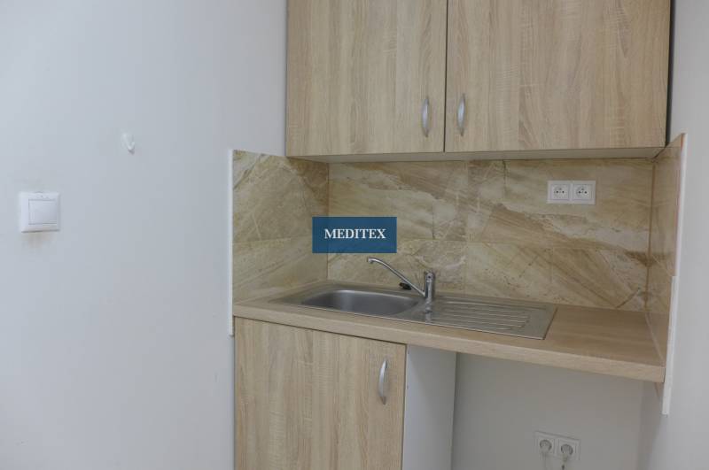 Kitchen corner in warehouses and halls with wooden cabinets and a sink.
