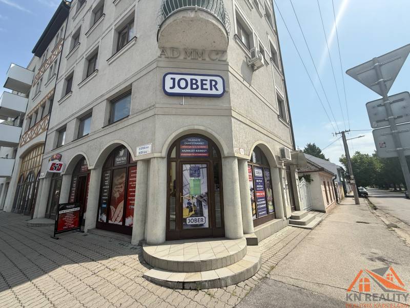 Commercial premises in Komárno on Petőfi Street with a sunny facade and advertising signs.