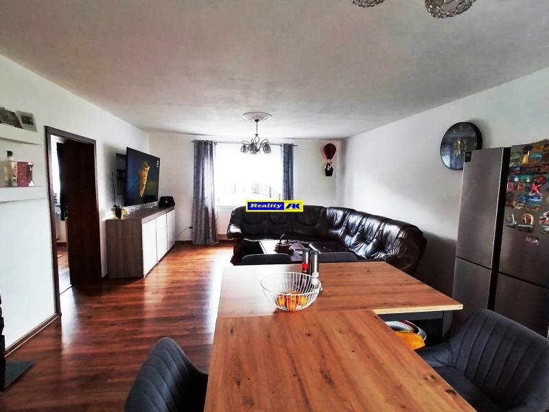 Living room in a family house with a leather sofa and a wall-mounted television.