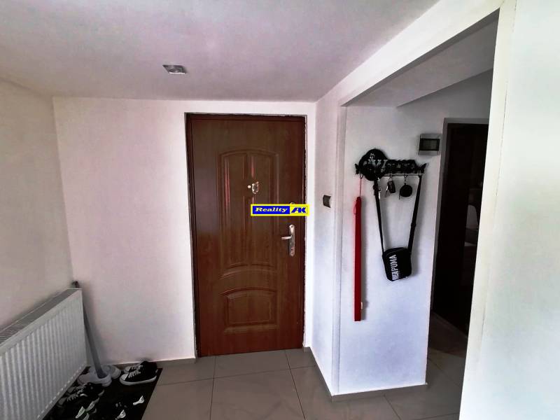 Entrance hallway in a family house with wooden doors, a key holder, and a radiator.