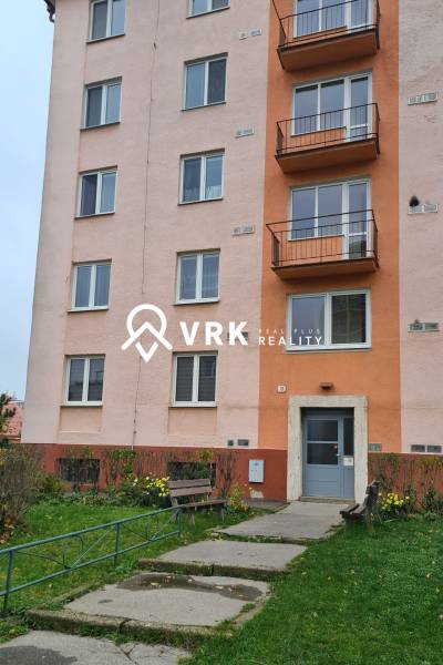 Building on Mudroňova Street, Košice - Juh district, with an entrance and a bench.