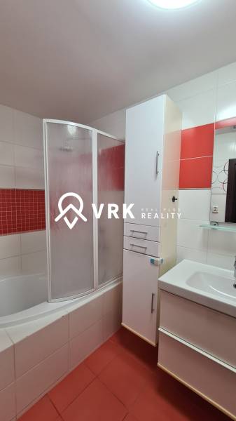 Bathroom in a 2-room apartment with a shower and a sink, red accents.