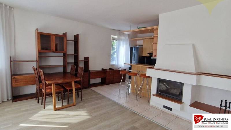 Living room in a family house with wooden furniture and a fireplace, dining table and chairs.