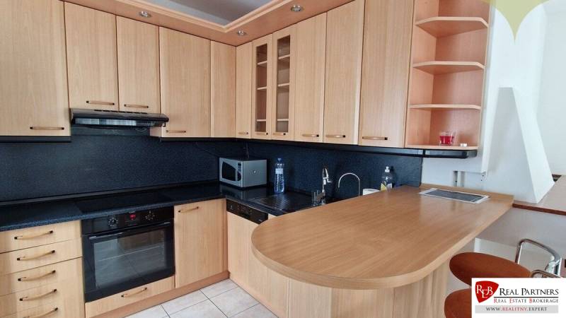 A wooden kitchen unit with black details in a family house.