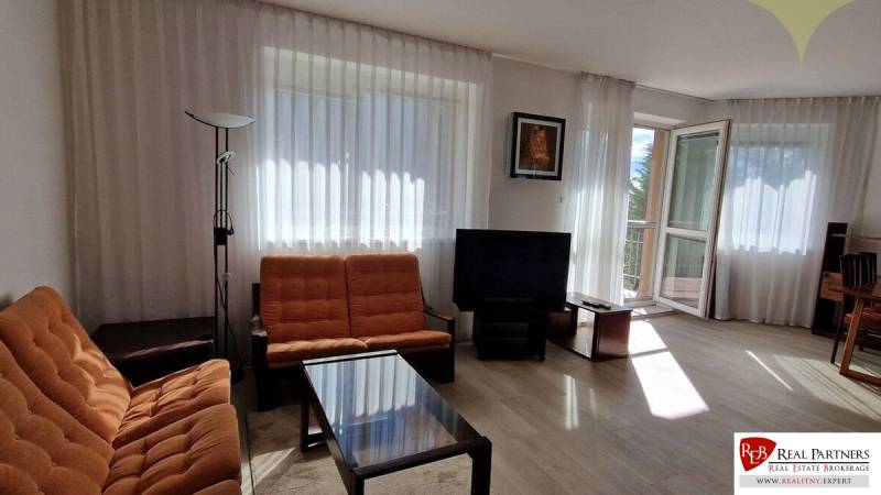 Living room with orange furniture, a television, and large windows, Family house.