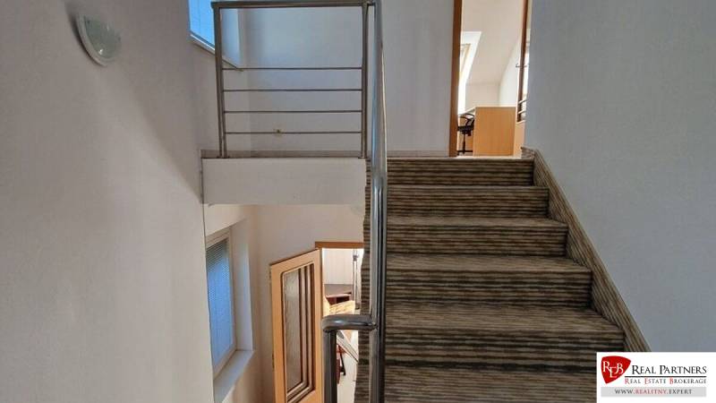 A staircase with carpet and railing in a family house, the rooms create a cozy atmosphere.