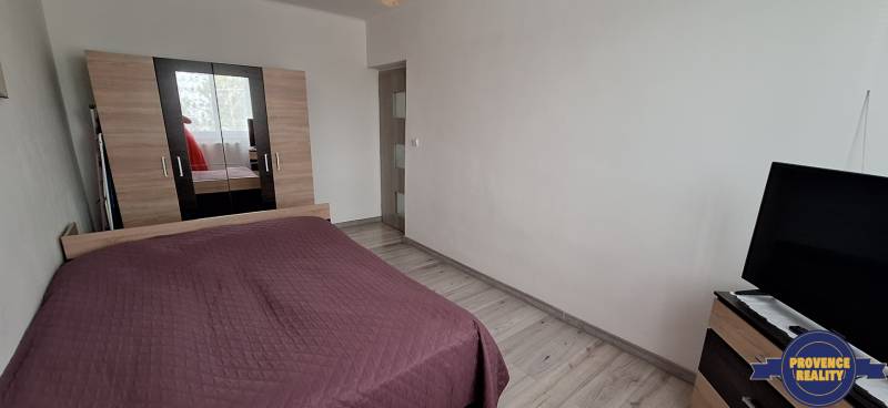 Bedroom with a bed, white walls, and a wardrobe, 3-room apartment.