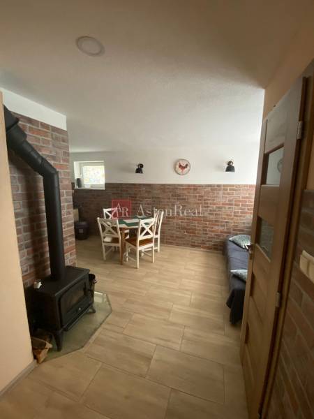A family house with a brick wall, a fireplace stove, and a dining nook with wooden furniture.