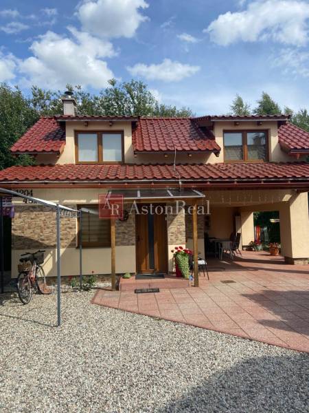 A family house on Liptovská Ondašová in Liptovský Mikuláš with a red roof and a garden seating area.