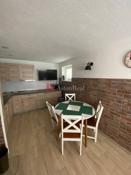 A kitchen with a dining table and brick cladding in a family house.