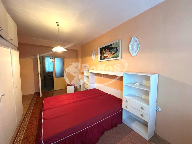 Bedroom in a 3-room apartment with a double bed, wardrobe, and wall decorations.