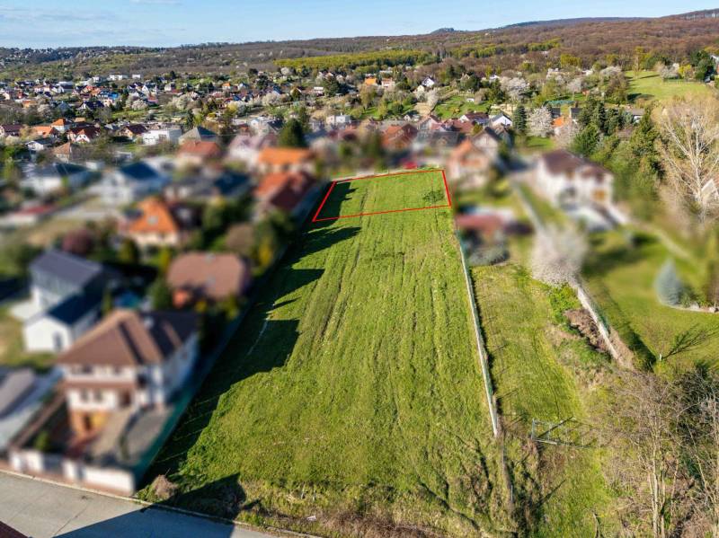 Building plot on Štúrova Street in Marianka, with a view of the surrounding development.