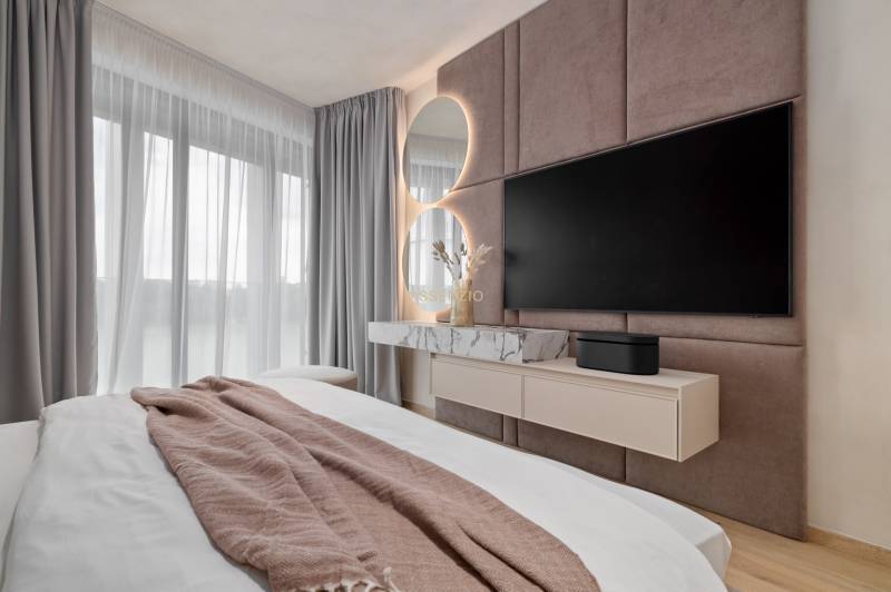 Bedroom in a 3-room apartment with a mirror, TV, and curtains.