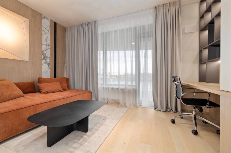 A bright living space in a 3-room apartment with a comfortable sofa and a work corner.