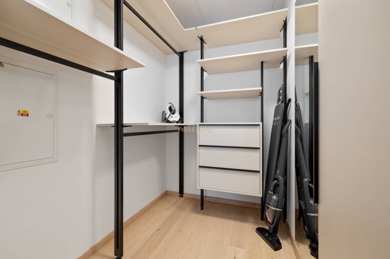 A wardrobe in a 3-room apartment with shelves, drawers, and cleaning tools.