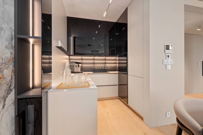 A stylish kitchen in a 3-room apartment with black and white elements, wooden floor.