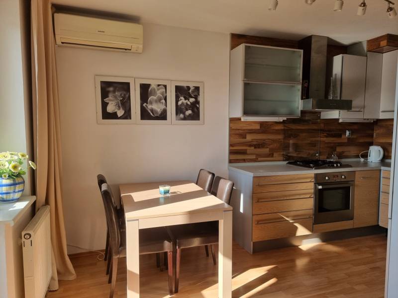 A kitchen with a table and chairs in a 4-room apartment, wooden cabinets, wall decorations.