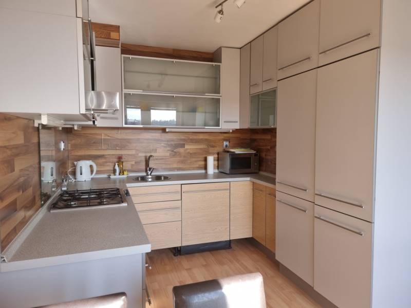 A kitchen in a 4-room apartment with wooden paneling and built-in appliances.