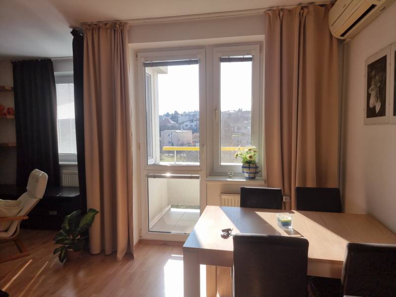 Dining room in a 4-room apartment with access to a balcony and a view of the city.