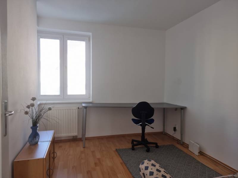 Spacious office in a 4-room apartment with a desk, chair, and simple decor.