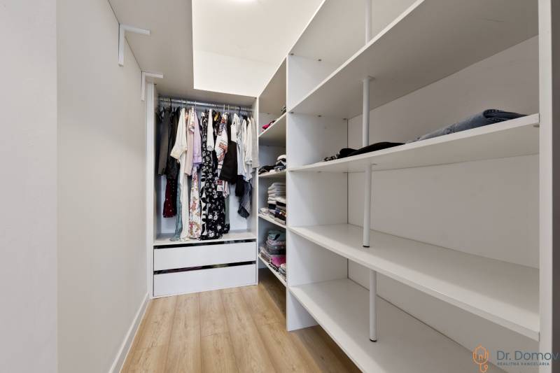 A wardrobe in a 2-room apartment with shelves and hanging space for clothes.