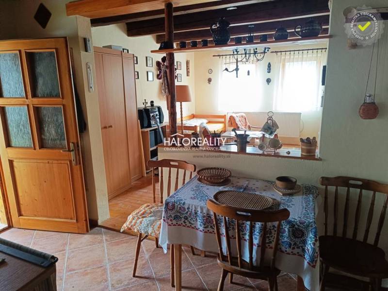 The interior of the cottage with wooden furniture, ceramic decorations, and pictures on the walls.