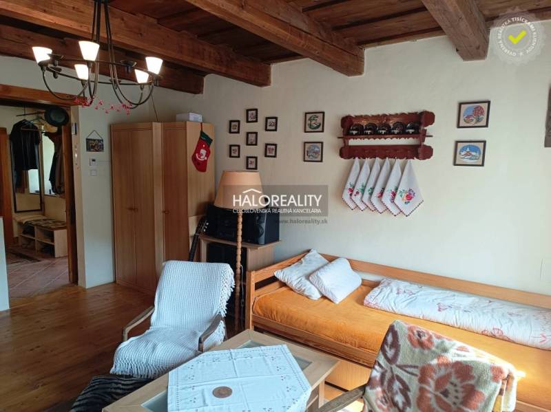 The interior of a cabin with a wooden ceiling, comfortable seating, and decorations on the wall.