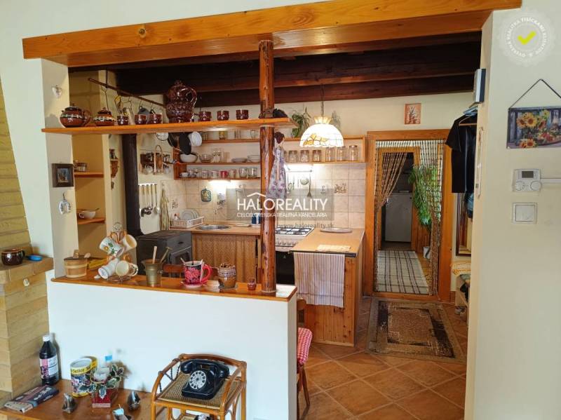 A kitchen in a cabin with wooden paneling, a traditional touch, and ceramic accessories.