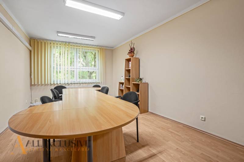 Dining table with a bookshelf and office chairs in the office.