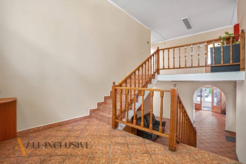 Office interior with wooden staircase and tiled floor.