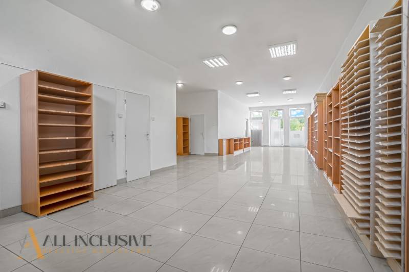 Interior of commercial premises with shelves and a well-lit entrance.