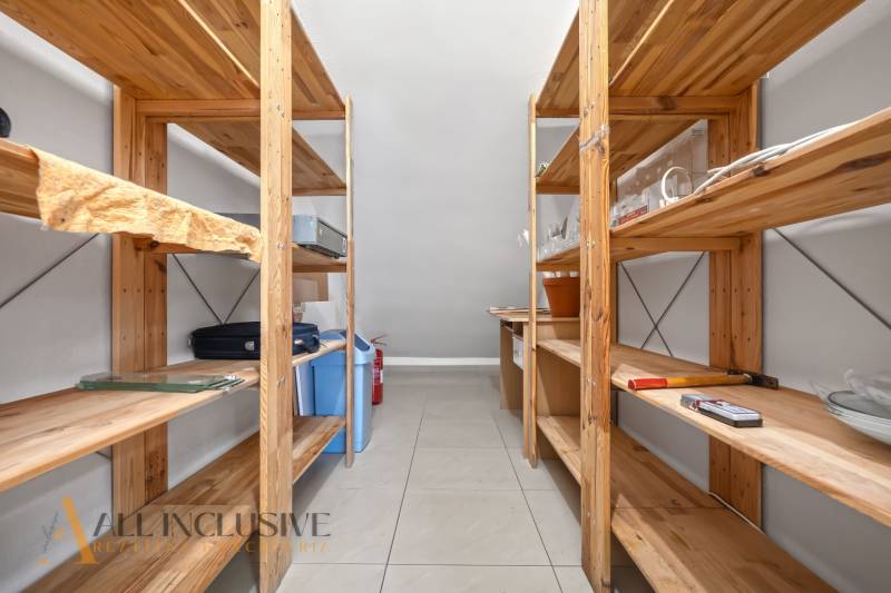 Wooden shelves in the storage area with various items on the tables.