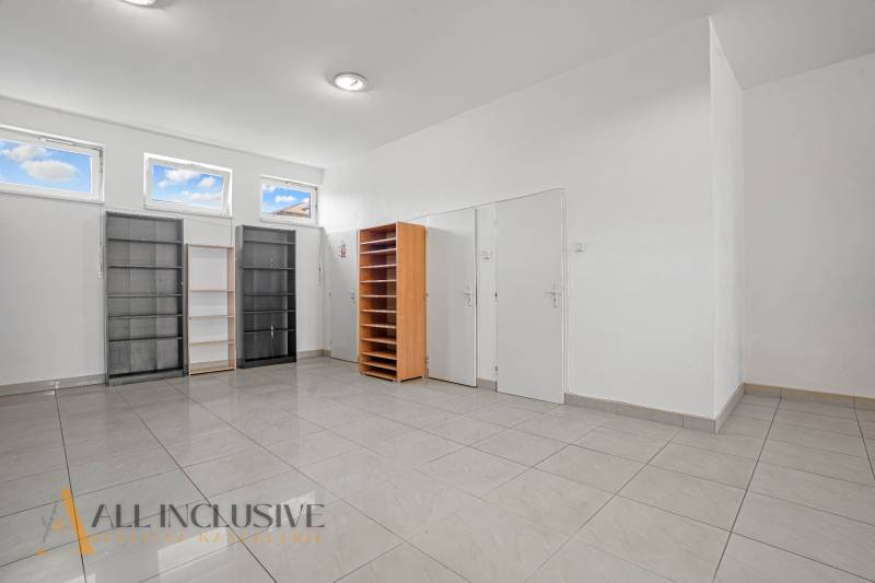 Commercial premises with shelves and light tiles, suitable for office use.