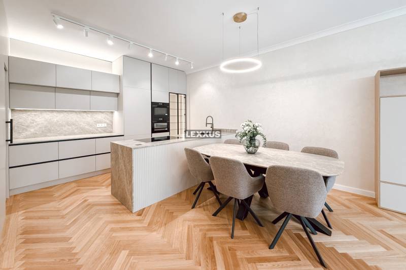 Dining area with an oval table, six chairs, and a kitchen island in a 4-room apartment.