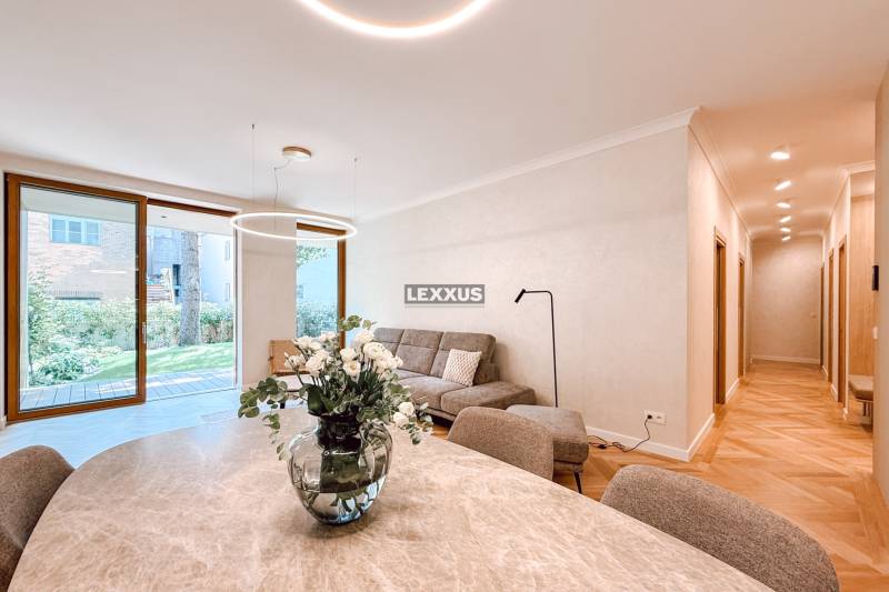 A stylish living area with a sofa and a vase with flowers in a 4-room apartment.