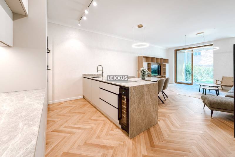 Living room and kitchen with an island in a 4-room apartment and wooden floors.