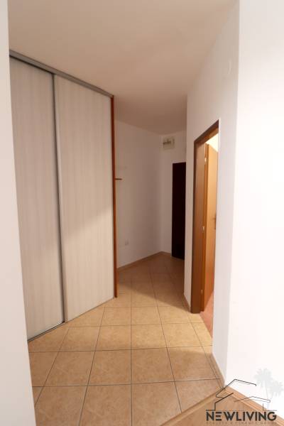 A hallway with a built-in wardrobe and tiles in a 2-room apartment.